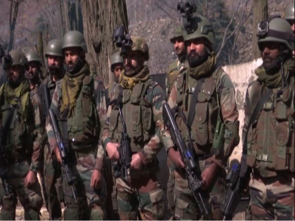 Illustrative photograph: a line of uniformed personnel in field equipment standing together outdoors in winter light.